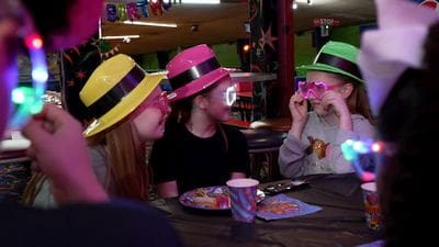 3 girls dressed in neon colors at a private kids roller skating party